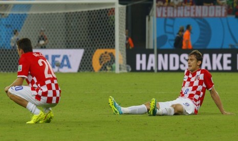 Pemain Timnas Kroasia, Mateo Kovacic (kiri) dan Nikica Jelavic, terduduk di lapangan usai menelan kekalahan dari Meksiko di laga terakhir Grup A Piala Dunia 2014 Brasil di Arena Pernambuco, Recife, Senin (23/6). 