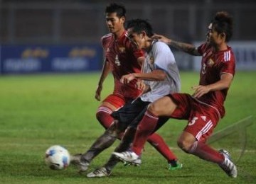 Pemain timnas Laos, Sangvone Phimmasen (tengah), berebut bola dengan dua pemain Myanmar, Moe Win (kanan) dan Zaw Min Tun, pada babak penyisihan Grup B SEA Games XXVI di Stadion Utama Gelora Bung Karno Senayan, Jakarta, Kamis (3/11) malam. 