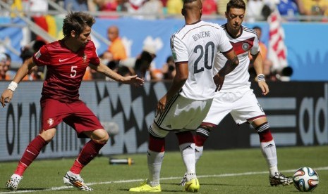 Pemain Timnas Portugal, Fabio Coentrao (kiri), berebut bola dengan pemain Jerman, Jerome Boateng dan Mesut Oezil (kanan), dalam laga Grup G Piala Dunia 2014 di Arena Fonte Nova, Salvador, Senin (16/6). 