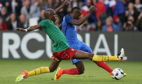 Pemain Timnas Prancis, Blaise Matuidi, diganjal pemain Kamerun, Allan Nyom, dalam laga internasional di Stadion La Beaujoire, Nantes, barat Prancis, pada 30 Mei 2016.  