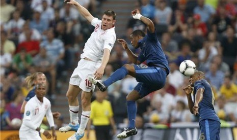 Pemain timnas Prancis, Florent Malouda (kanan) dan Patrice Evra, terlibat duel udara dengan gelandang Inggris, James Milner, di laga Grup D Piala Eropa 2012 di Donbass Arena, Donetsk, Ukraina, Senin (11/6). 