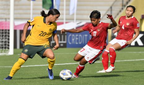 Pemain Timnas putri Indonesia Vivi Oktavia Riski (tengah) berebut bola dengan pemain Timnas putri Australia Samantha Kerr (kiri) dalam laga Grup B Piala Asia 2022 di Stadion Mumbai Football Arena, Mumbai, India, Jumat (21/1/2022). Indonesia kalah 18-0.