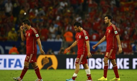 Pemain Timnas Spanyol (kiri-kanan) Koke, Santi Cazorla, dan Sergio Busquets berjalan gontai usai menelan kekalahan 0-2 dari Cile di laga kedua Grup B Piala Dunia 2014 di Stadion Maracana, Rio de Janeiro, Rabu (18/6). 