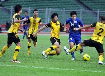 Pemain Timnas Thailand, Natarid Thammroddodpon (biru), dikerubuti pemain Timnas Malaysia saat pertandingan lanjutan kualifikasi Grup A SEA Games ke-26 di Stadion Utama Gelora Bung Karno, Jakarta, Rabu (9/11).