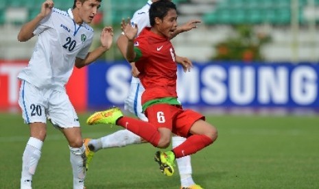 Pemain timnas U-19 Indonesia Evan Dimas (tengah) diapit pesepakbola timnas U-19 Uzbekistan.