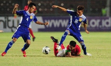 Pemain timnas U-19 Indonesia, Evan Dimas, terjatuh saat duel dengan pemain Laos di kualifikasi Piala Asia (AFC) di Stadion Gelora Bung Karno, Selasa (8/10) malam WIB.