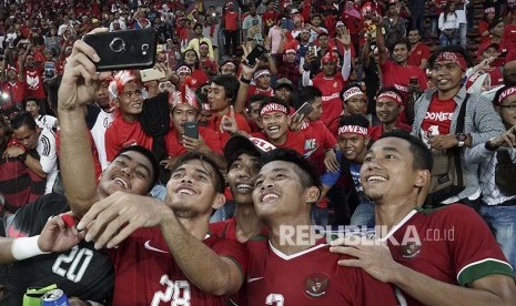 Pemain Timnas U-22 berfoto dengan suporter setelah mengalahkan Filipina pada babak penyisihan Grup B SEA Games XXIX di Stadion Shah Alam, Selangor, Malaysia, Kamis (17/8). Indonesia menang atas Filipina dengan skor 3-0.