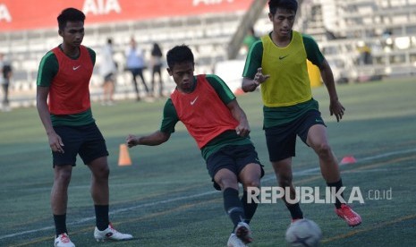 Pemain Timnas U-22 Hanif Abdurrauf Sjahbandi (kanan) berebut bola dengan rekannya Fredyan Wahyu (tengah) dalam latihan menjelang pertandingan Sepak Bola AFF U-22 di lapangan Stadion AIA - Home Of Western, Phnom Penh, Kamboja, Kamis (21/2/2019). 