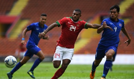 Pemain Timnas U-22 Marinus Mariyanto Wanewar (tengah) bersiap menerima bola dibayangi pemain Timnas Thailand U-22 Worawut Namvech (kanan) dalam penyisihan grup B SEA Games XXIX Kuala Lumpur 2017 di Stadion Shah Alam, Selangor, Malaysia, Selasa (15/8).