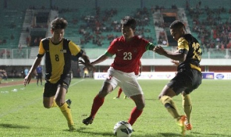  Pemain timnas U-23 Indonesia, Bayu Gatra berebut bola dengan pemain timnas U-21 Malaysia, Syahrul Igwan (kiri) di Stadion Maguwoharjo, Sleman, Rabu (5/3).