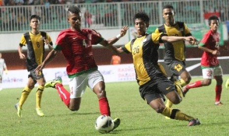  Pemain timnas Indonesia U-23, Syahrizal (dua kiri) berebut bola dengan pemain timnas U-21 Malaysia, Mohamad Irfan di Stadion Maguwoharjo, Sleman, Rabu (5/3).