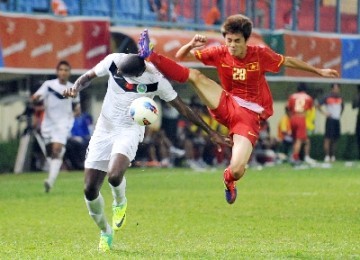 Pemain Timnas U23 Timor Leste, Alan Leandro Da Silva (kiri), berebut bola dengan pemain Vietnam, Lam Anh Quang, saat bertanding pada penyisihan Grup B sepak bola SEA Games 2011 di Stadion Lebak Bulus, Jakarta Selatan, Rabu (9/11).