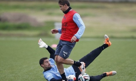 Pemain Timnas Uruguay, Martin Silva (di tanah) dan Gaston Ramirez, dalam sesi latihan di Motevideo pada 21 Mei. 