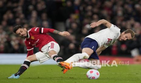 Pemain Tottenham Harry Kane (kanan) beraksi melawan pemain Manchester United Alex Telles (kiri) saat pertandingan sepak bola Liga Utama Inggris antara Manchester United dan Tottenham Hotspur di Manchester, Inggris, Ahad (13/3) dini hari WIB. 