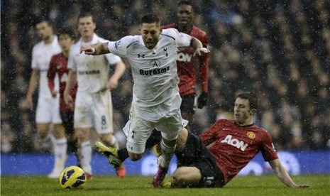 Pemain Tottenham Hotspur, Clint Dempsey (tengah), terlibat duel dengan pemain Manchester United, Michael Carrick, pada laga Liga Primer Inggris di White Hart Lane, London, akhir Januari lalu.  