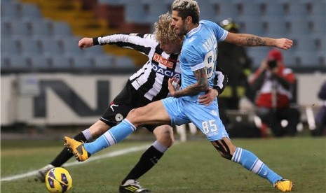 Pemain Udinese, Dusan Basta (kiri), berebut bola dengan pemain Napoli, Valon Behrami, di laga Seri A Italia di Stadion Friuli, Udinese, Senin (25/2). 