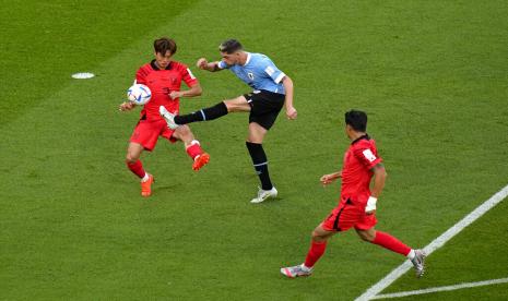  Pemain Uruguay Facundo Pellistri (tengah) menendang bola saat pemain Korea Selatan Kim Jin-su, pergi, menantangnya selama pertandingan sepak bola grup H Piala Dunia antara Uruguay dan Korea Selatan, di Stadion Education City di Al Rayyan, Qatar, Kamis (24/11/2022).