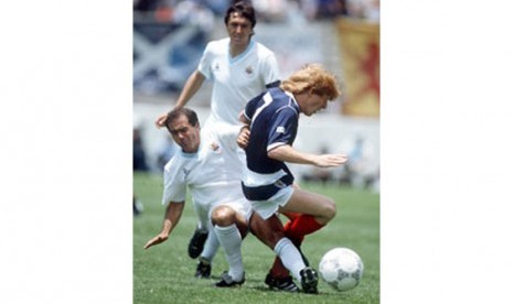 Pemain Uruguay, Jose Batista (kiri), menjegal pemain Skotlandia, Gordon Strachan, dalam laga Piala Dunia 1986.