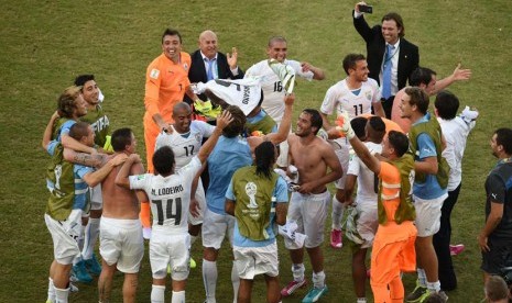 Pemain Uruguay merayakan setelah memenangkan 2014 grup Piala Dunia FIFA D pertandingan babak penyisihan antara Italia dan Uruguay di Estadio Arena das Dunas di Natal, Selasa (24/6). (EPA/Vassil Donev).