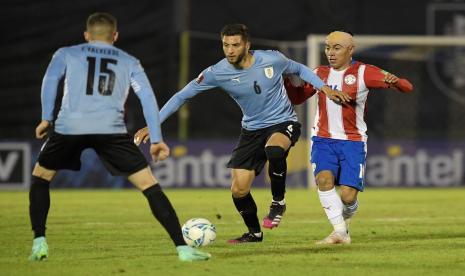 Pemain Uruguay Rodrigo Bentancur (tengah) dijaga oleh pemain Paraguay Angel Cardozo dalam laga kualifikasi Piala Dunia 2022 zona Conmebol.