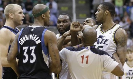 Pemain Utah Jazz, Al Jefferson (tengah), terlibat adu mulut dengan pemain Minnesota Timberwolves dalam laga NBA. 