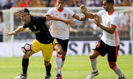 Pemain Valencia, Joao Cancelo dan Martin Montoya berebut bola dengan penggawa Atletico Madrid, Filipe Luis. Atletico Madrid sukses mengalahkan Valencia dengan skor 2-0, Ahad (2/10).