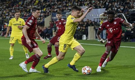 Pemain Villarreal Juan Foyth, tengah, berebut bola dengan pemain Bayern Kingsley Coman, kanan, pada pertandingan sepak bola leg pertama perempat final Liga Champions antara Villarreal dan Bayern Munich di stadion Ceramica di Villarreal, Spanyol, Rabu, 6 April 2022.