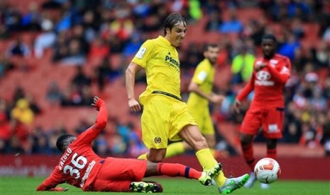 Pemain Villarreal Tomas Vina yang membawa bola coba diadang pemain Olympique Lyon dalam laga Emirates Cup, Ahad (26/7).