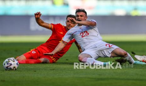 Pemain Wales Aaron Ramsey (kiri) berebut bola dengan  pemain Swiss Xherdan Shaqiri pada pertandingan grup A Piala Eropa 2020 antara Wales dan Swiss, di stadion Olimpiade Baku, di Baku, Azerbaijan, Sabtu (12/6).