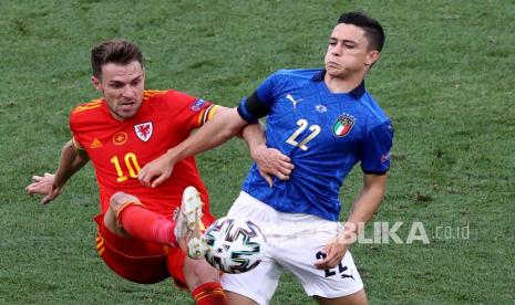 Pemain Wales Aaron Ramsey (kiri) dan pemain Italia Giacomo Raspadori berebut bola pada pertandingan grup A kejuaraan sepak bola Euro 2020 antara Italia dan Wales di stadion Stadio Olimpico di Roma, Ahad (20/6).