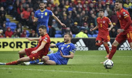 Pemain Wales Ben Davies, kiri bawah, berebut bola dengan pemain Ukraina Andriy Yarmolenko selama pertandingan play-off kualifikasi Piala Dunia 2022 antara Wales dan Ukraina di Stadion Cardiff City, di Cardiff, Wales, Ahad, 5 Juni 2022.