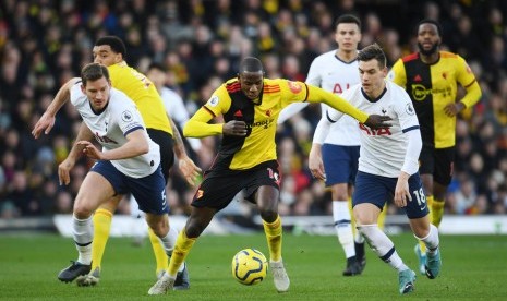 Pemain Watford Abdoulaye Doucoure (tengah) dijaga dua pemain Tottenham Hotspur dalam pertandingan Liga Inggris, Sabtu (18/1).