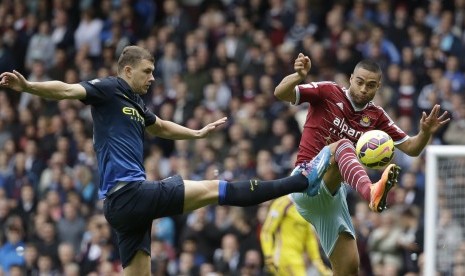 Pemain West Ham, Edin Dzeko (kiri) berebut bola dengan pemain Manchester City, Winston Reid di laga Liga Primer Inggris, di London, Sabtu (25/10).