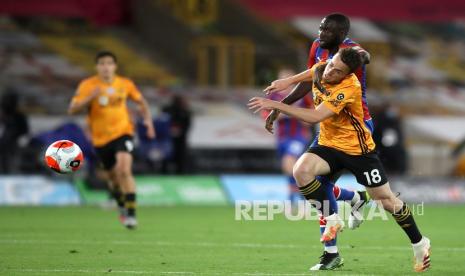 Pemain Wolverhampton Wanderers Diogo Jota (kanan)  dan pemain Crystal Palace  Cheikhou Kouyate berebut bola pada  pertandingan sepak bola Liga Primer Inggris antara Wolverhampton Wanderers dan Crystal Palace di Stadion Molineux di Wolverhampton, Inggris, Senin (20/7/2020). 