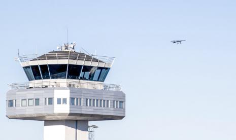 Pemandangan menara kontrol lalu lintas udara di Bandara Flesland saat pesawat baling-baling kecil terbang di latar belakang, di Bergen, Norwegia, Rabu, 19 Oktober 2022. Pihak berwenang mengatakan bandara di kota terbesar kedua di Norwegia itu ditutup sebentar setelah setidaknya satu drone terlihat di dekatnya oleh penduduk daerah. Seorang juru bicara polisi mengatakan penampakan drone pertama di Bandara Bergen dilaporkan pada pukul 04:15 pada hari Rabu.