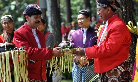 Pemangku adat menyerahkan kendi berisi air kepada walikota Magelang Sigit Widyonindito (kanan) saat berlangsung prosesi penyatuan tanah dan air di gunung Tidar Kota Magelang, JRabu (6/9). Prosesi tersebut sebagai tanda dimulainya pembangunan monumen Tanah dan Air di puncak Gunung Tidar dalam rangkaian HAORNAS 2017. 