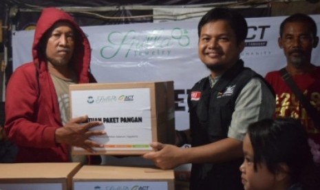 Pembagian bantuan paket pangan kepada masyarakat Kampung Pemulung  oleh ACT DIY di Kabupaten Sleman, Senin (4/3). 