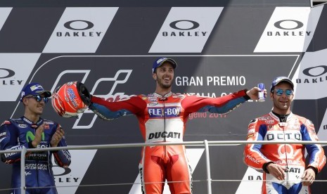 Pembalap Ducati, Andrea Dovizioso (tengah) dari Italia, pemenang grand prix Moto GP Italia. Posisi kedua oleh pembalap Yamaha, Maverick Vinales (kiri) dari Spanyol, dan urutan ketiga diraih pembalap Ducati, Danilo Petrucci, dari Italia. Di Mugello Sirkuit, Scarperia, Italia, Minggu (4/6).