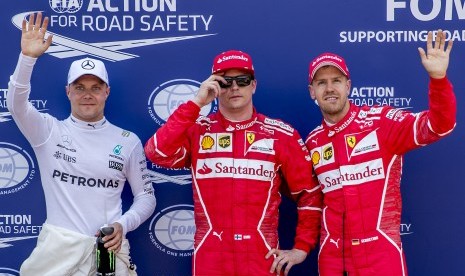 Pembalap Ferrari, Kimi Raikkonen (tengah) diapit rekan setimnya, Sebastian Vettel (kanan) dan pembalap Mercedes, Valtteri Bottas seusai babak kualifikasi GP Monako, Sabtu (27/5). Raikkonen menjadi yang tercepat pada babak kualifikasi ini.