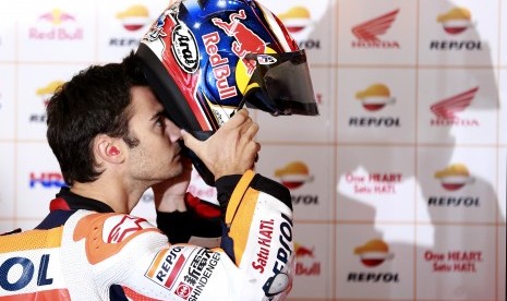 Pembalap Honda Repsol, Dani Pedrosa mengenakan helm sebelum memulai latihan bebas di sirkuit Motegi, Jepang, Jumat (14/10). Pada latihan bebas kedua, Pedrosa mengalami kecelakaan.