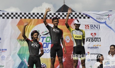 Pembalap Indonesia Muh Imam Arifin (tengah) bersama Fitrianto Hari (kanan) dan Hibatullah Jamal Etape (kiri) melambaikan tangan saat penganugerahan juara Balap Sepeda Tour de Flores (TDF) 2017 di Labuan Bajo, NTT, Rabu (19/7).