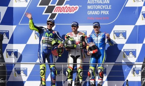 Pembalap LCR Honda, Cal Crutchlow (tengah) diapit oleh Valentino Rossi (kiri) dan Maverick Vinales di atas podium sirkuit Philip Island, Australia, Ahad (23/10). Rossi meraih podium kedua sementara Vinales finis ketiga.