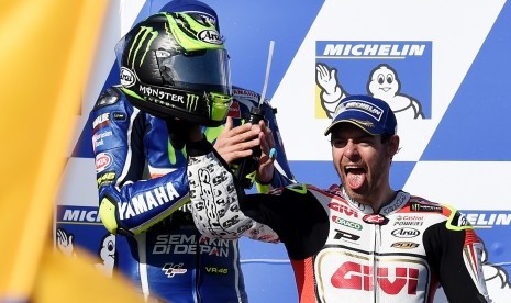 Pembalap LCR Honda (kanan) merayakan kemenangannya di podium sirkuit Philip Island, Australia bersama Valentino Rossi, Ahad (23/10).