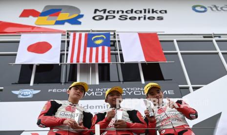 Pembalap Malaysia Hakim Danish (tengah) bersama pembalap Jepang Shinya Ezawa (kiri) dan pembalap Indonesia Reykat Yusuf Fadillah (kanan) berfoto di podium usai race 1 Idemitsu Asia Talent Cup (IATC) 2022 seri Pertamina Grand Prix of Indonesia di Pertamina Mandalika International Street Circuit, Lombok Tengah, NTB, Sabtu (19/3/2022). Pembalap Malaysia Hakim Danish berhasil menjadi juara pertama diikuti pembalap Jepang Shinya Ezawa dan pembalap Indonesia Reykat Yusuf Fadillah.