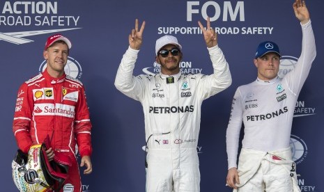 Pembalap Mercedes AMG GP asal Inggris Lewis Hamilton (tengah) mencatat waktu tercepat pada sesi kualififikasi balapan di Sirkuit Amerika, Texas, Ahad (22/10) dini hari WIB. Hamilton lebih cepat dibandingkan Sebastian Vettel (kiri) dari Ferrari dan rekan setimnya, Valtteri Bottas (kanan).