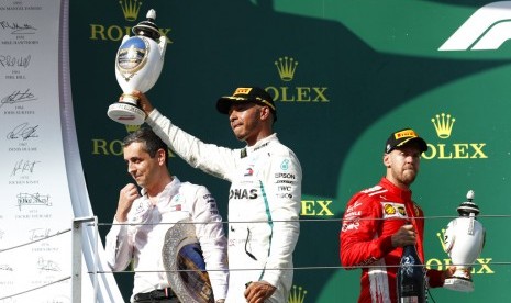 Pembalap Mercedes, Lewis Hamilton (tengah) menjadi juara GP Hungaria, di Sirkuit Hungaroring, Ahad (29/7).