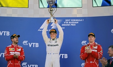 Pembalap Mercedes Valtteri Bottas (tengah) merayakan keberhasilannya menjuarai GP F1 Rusia, Ahad (30/4).