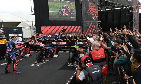 Pembalap Pata Yamaha With Brixx WorldSBK Toprak Razgatlioglu melemparkan topi kepada para penggemarnya usai meraih trofi SBK Tissot Superpole pada sesi kualifikasi WSBK Indonesia 2021 di Pertamina Mandalika International Street Circuit, Lombok Tengah, Nusa Tenggara Barat, Sabtu (20/11/2021).