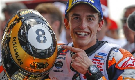 Pembalap Repsol Honda, Marc Marquez menunjukkan helm yang menunjukkan simbol gelar kedelapannya di kelas MotoGP. Marquez menyegel gelar juara dunia MotoGP tahun ini setelah menjadi juara di GP Thailand, di Sirkuit Buriram, Thailand, Ahad (6/10).