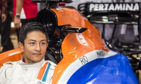 Pembalap Tim Manor Racing Rio Haryanto berpose di mobilnya usai jumpa pers di Jakarta, Senin (14/3). 